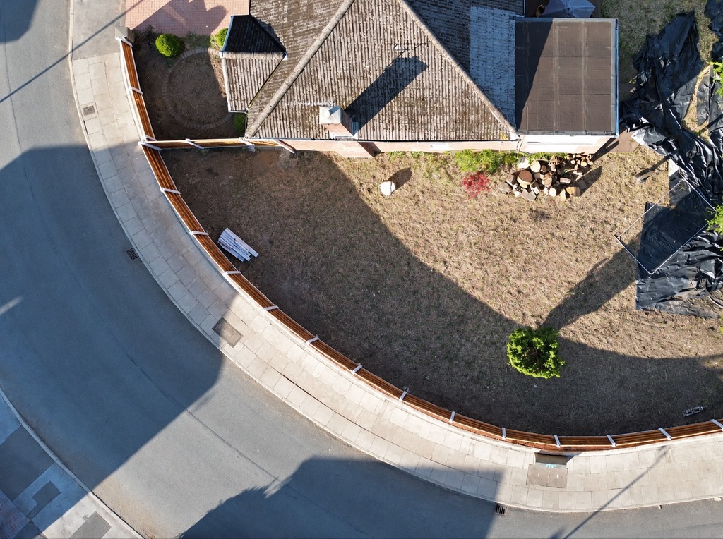 The same Unsworth corner plot from above, cleared and with a new timber fence following the curve